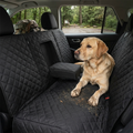 Labrador lying on the waterproof dog back seat cover after a muddy hike, protecting the car seat